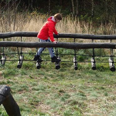 Person går balancegang i naturen.