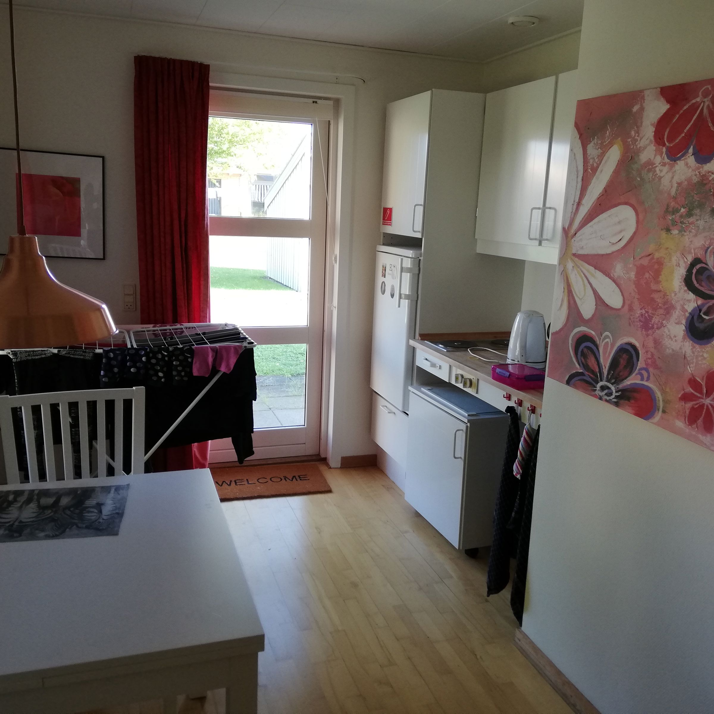 Eksempel på bolig i Vibo. Der et et lille køleskab og et spisebord med nogle stole.