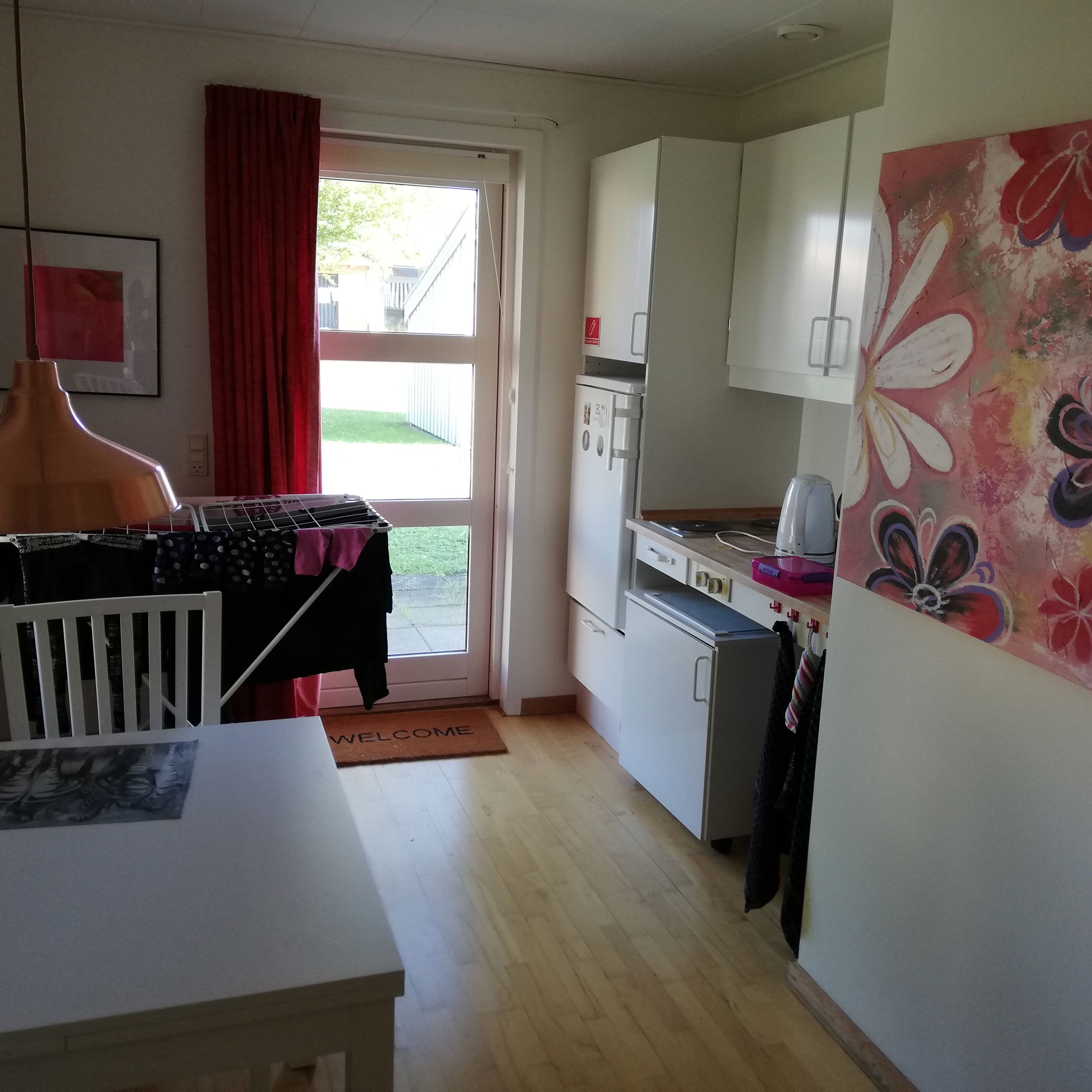 Eksempel på bolig i Vibo. Der et et lille køleskab og et spisebord med nogle stole.