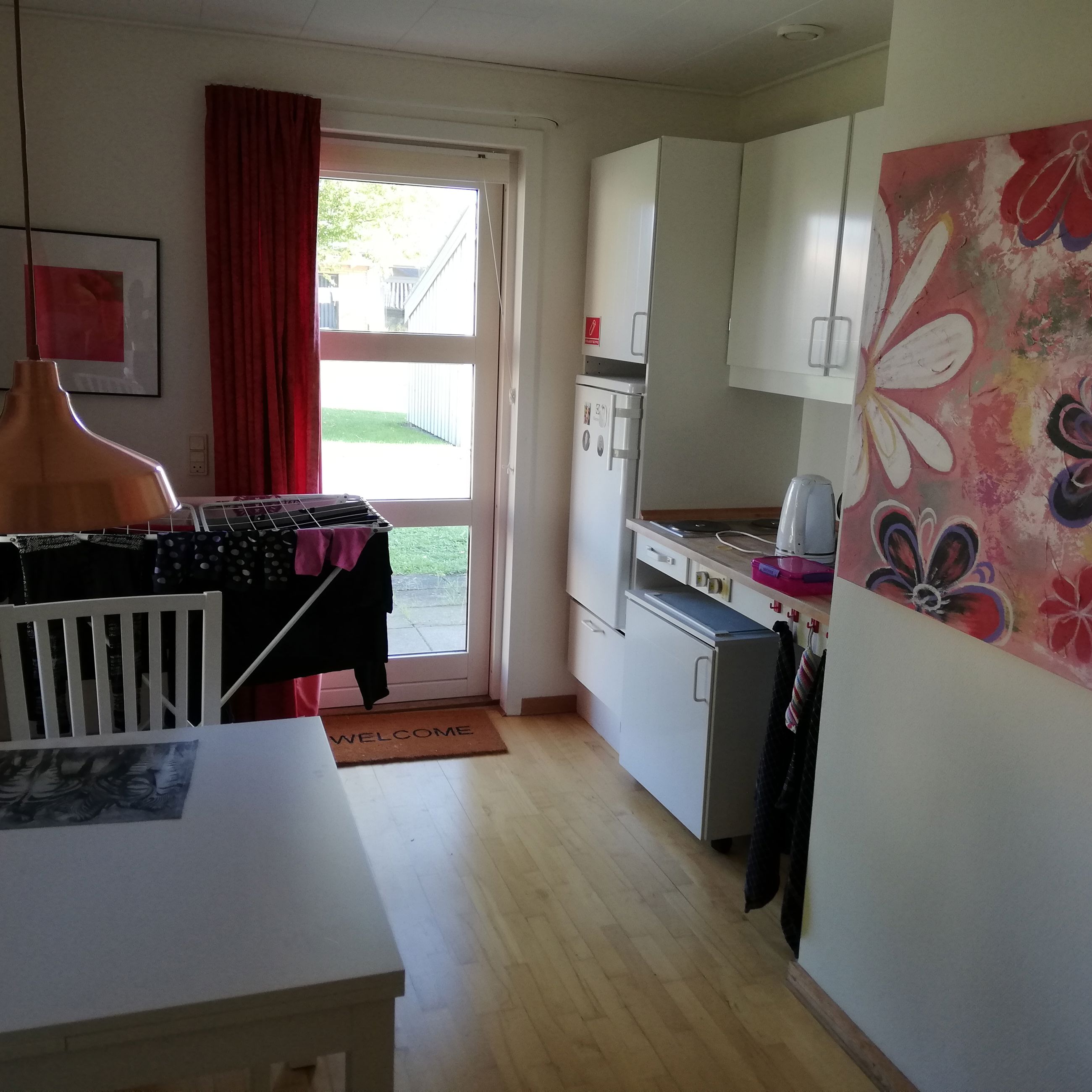 Eksempel på bolig i Vibo. Der et et lille køleskab og et spisebord med nogle stole.