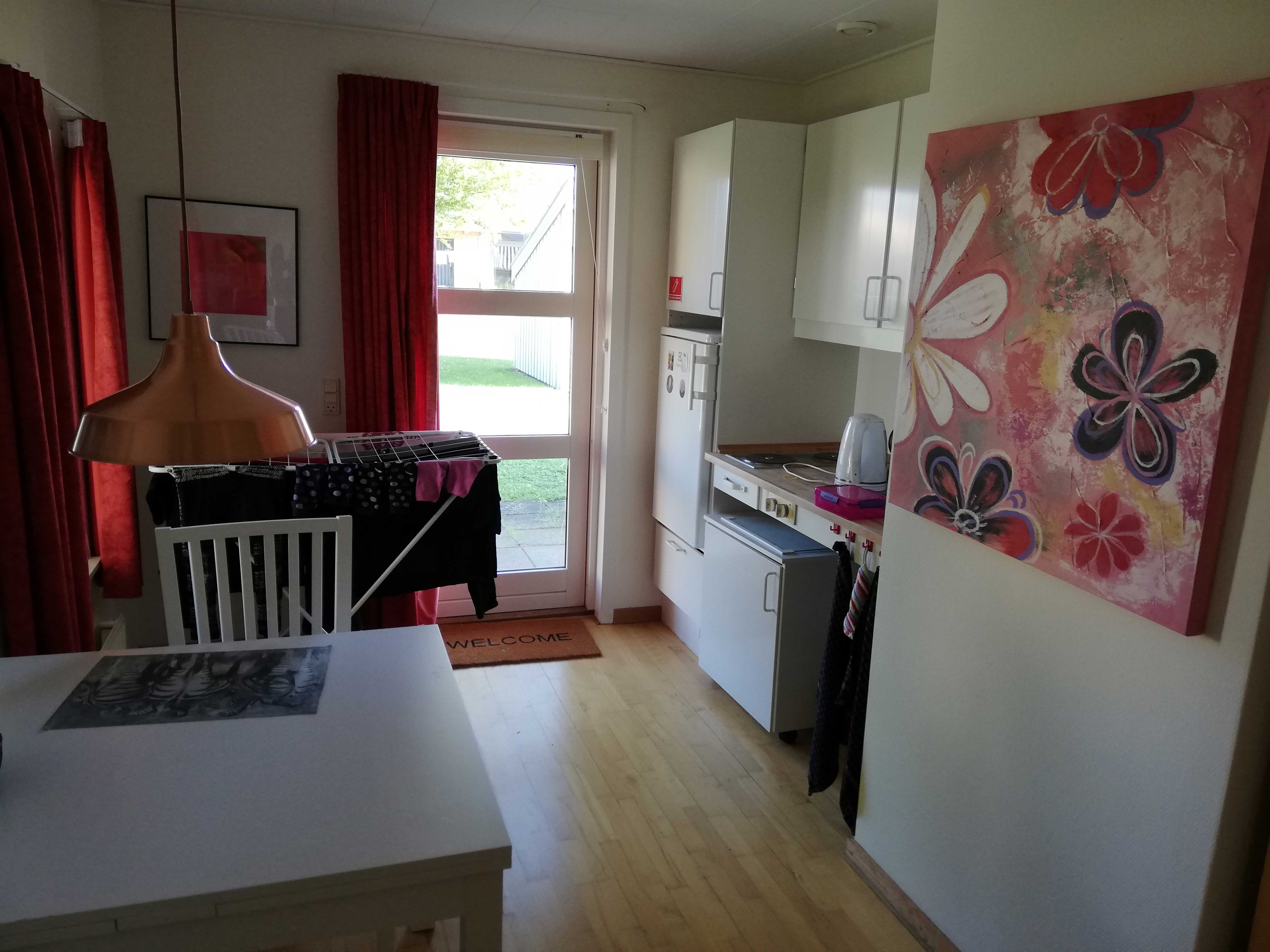 Eksempel på bolig i Vibo. Der et et lille køleskab og et spisebord med nogle stole.