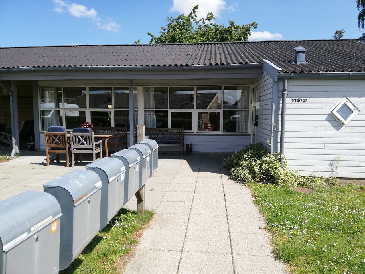 Vibo set udefra. Der er postkasser og en masse græs.