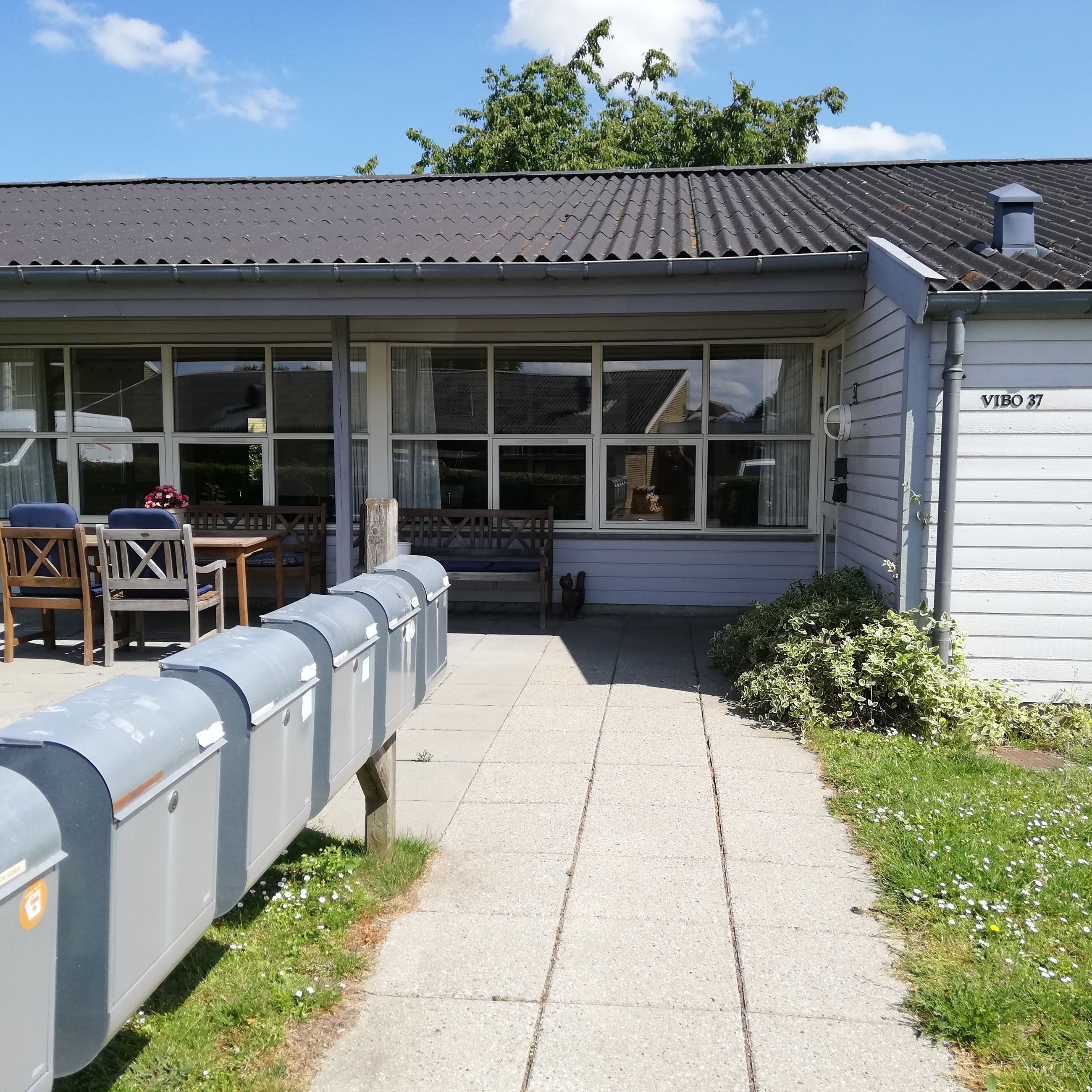 Vibo set udefra. Der er postkasser og en masse græs.