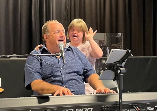 To personer synger. Den ene spiller også på keyboard.