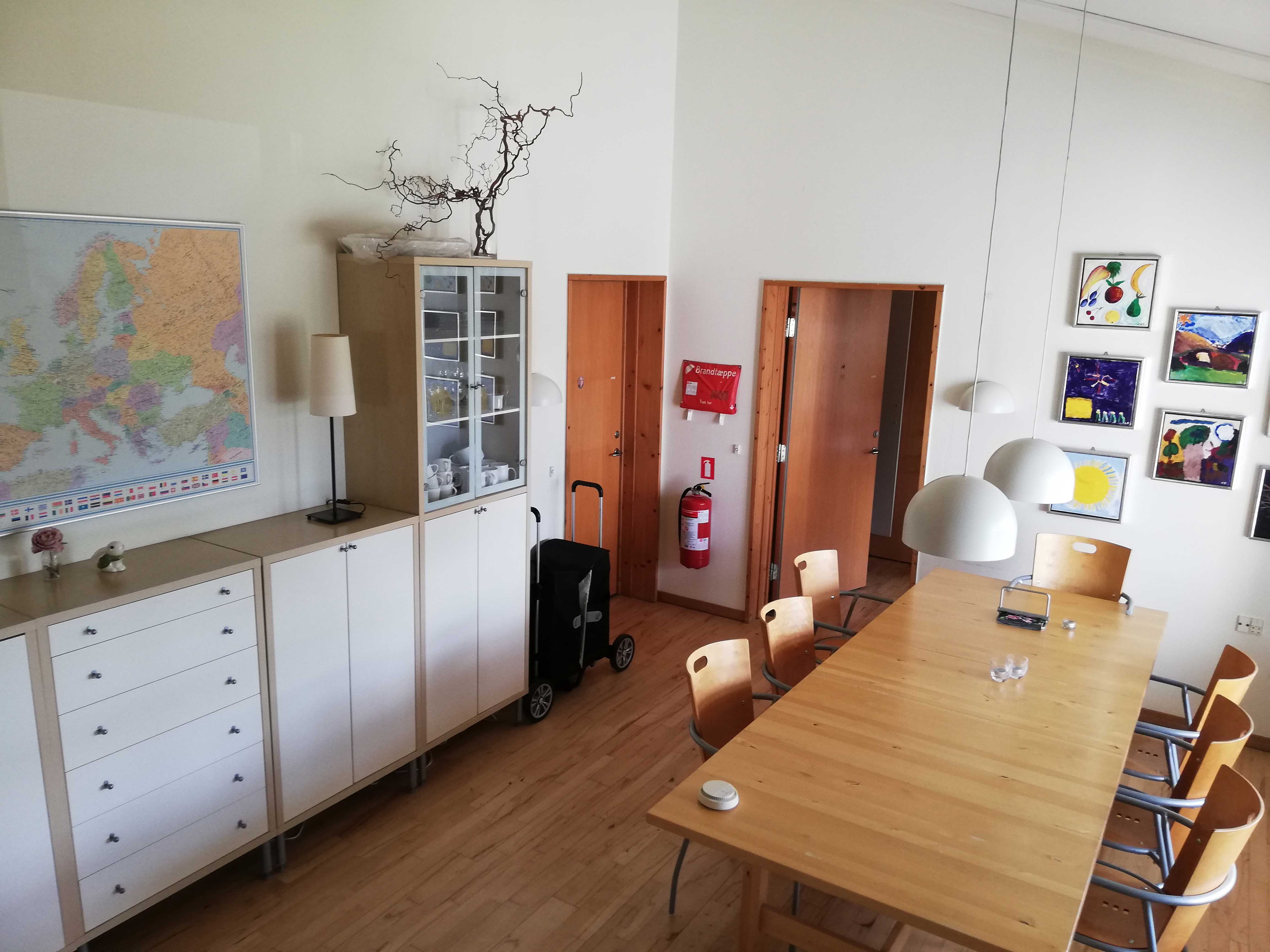 Vibo set indefra. Der er en masse fine møbler og et bord med seks stole.