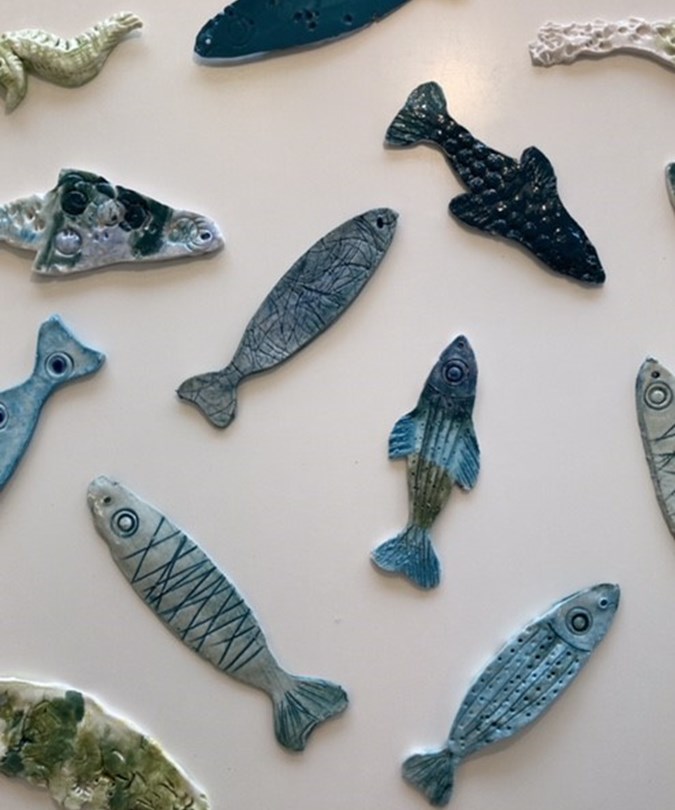 Fisk i keramik. Der er forskellige slags fisk, og de er alle en form for blå eller grøn.