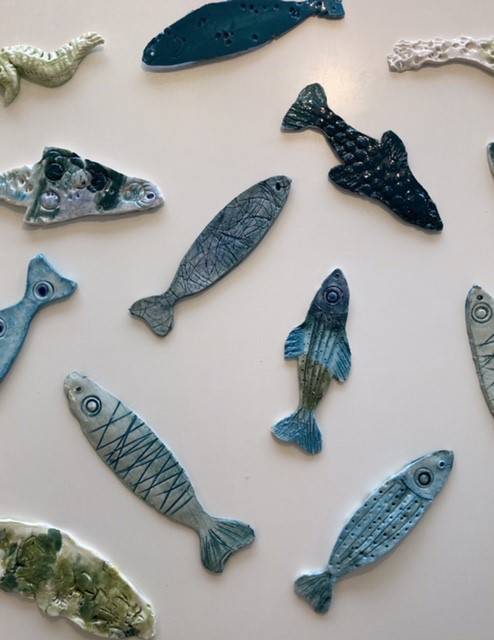 Fisk i keramik. Der er forskellige slags fisk, og de er alle en form for blå eller grøn.