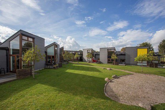 Bostedet Koglerne set udefra. Der er grønt og himlen er blå.