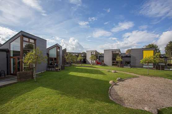 Bostedet Koglerne set udefra. Der er grønt og himlen er blå.