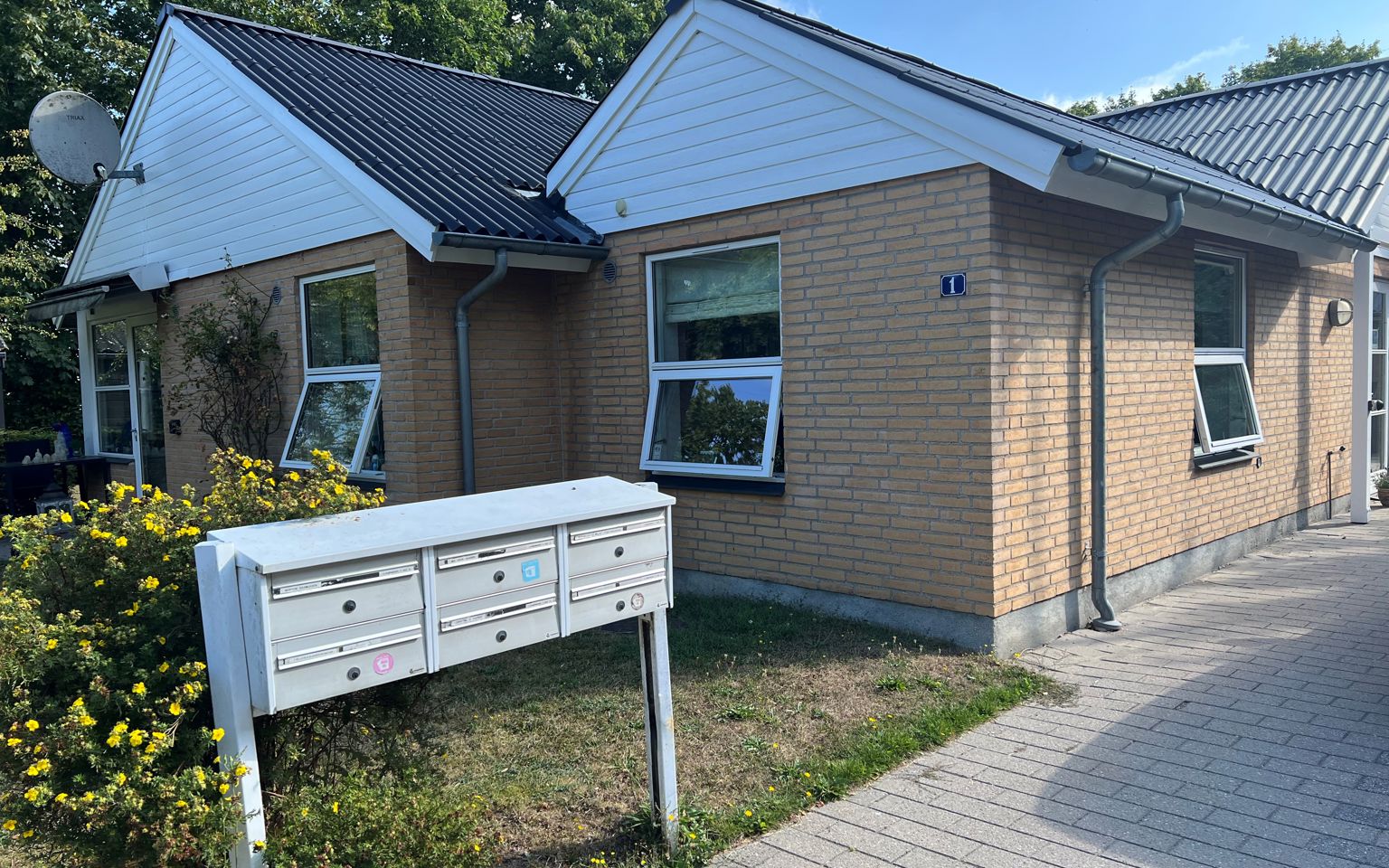 Lyngbakken set udefra. Der er et bord og seks stole.