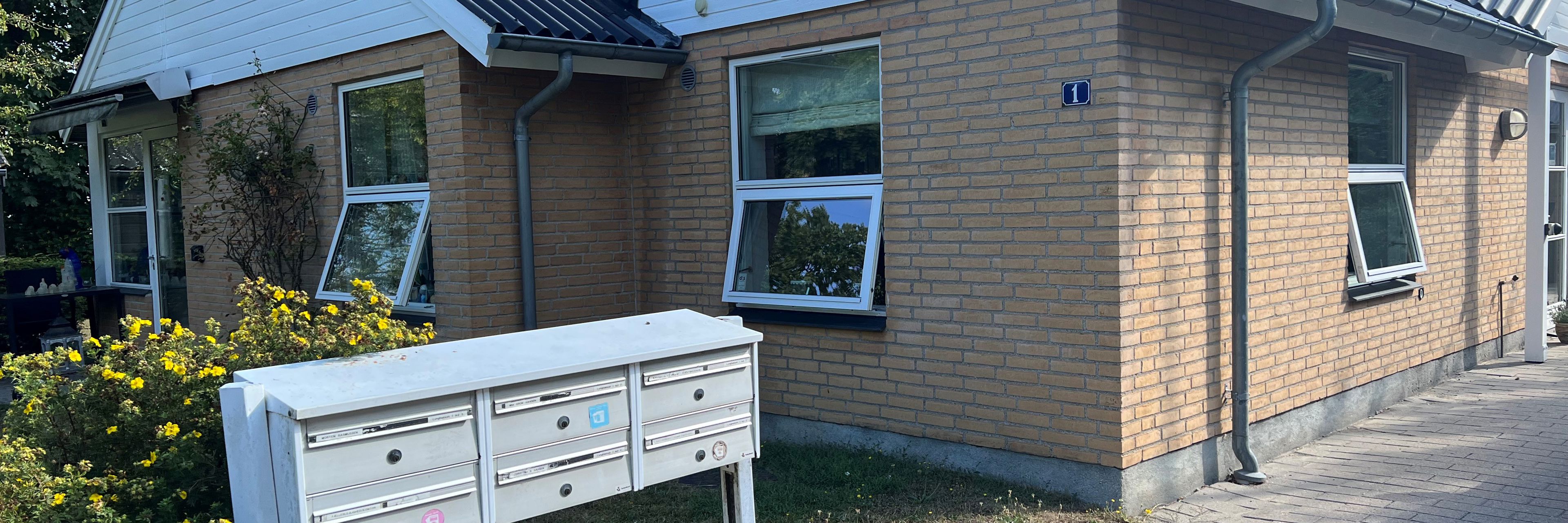 Lyngbakken set udefra. Der er et bord og seks stole.