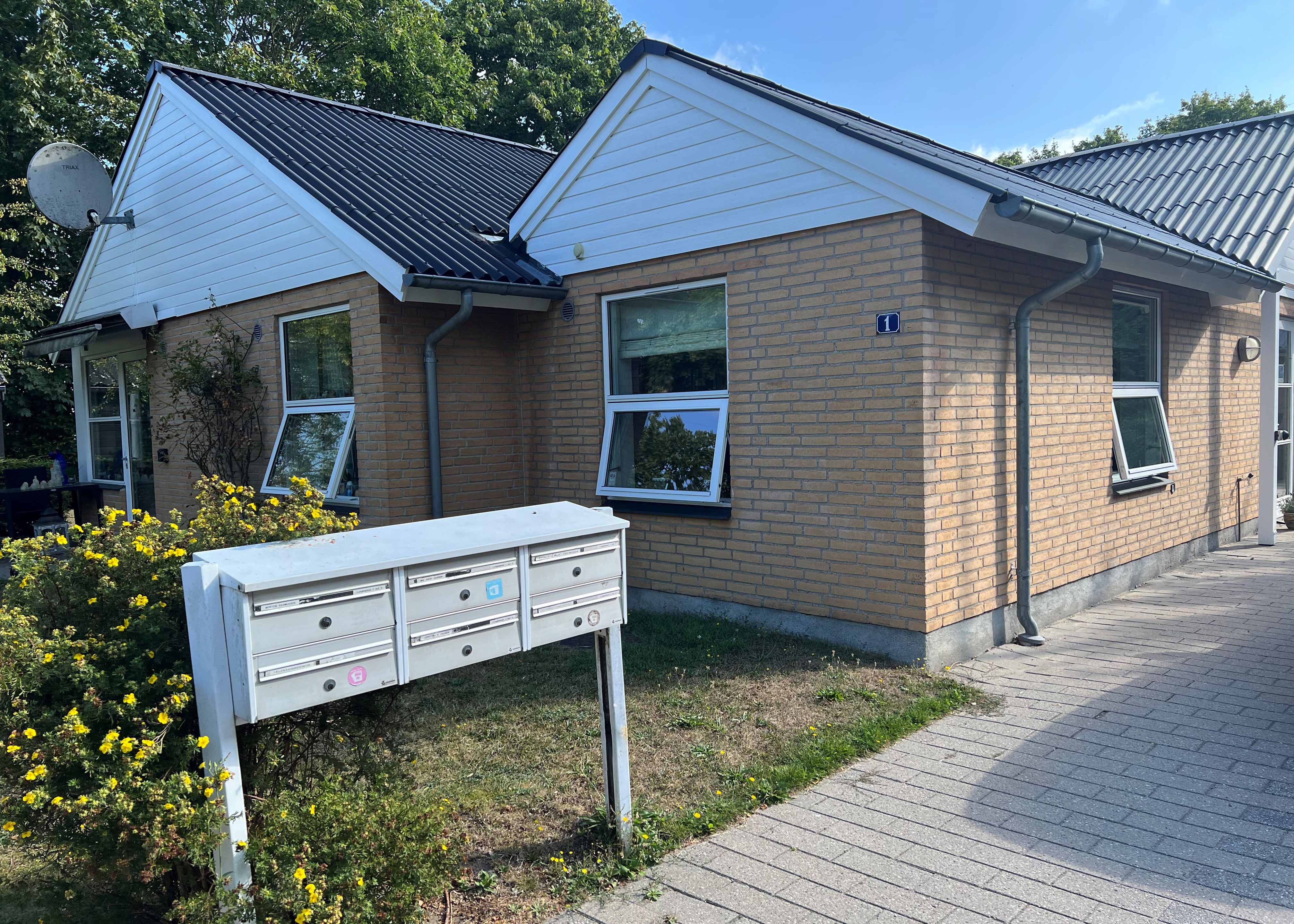 Lyngbakken set udefra. Der er et bord og seks stole.