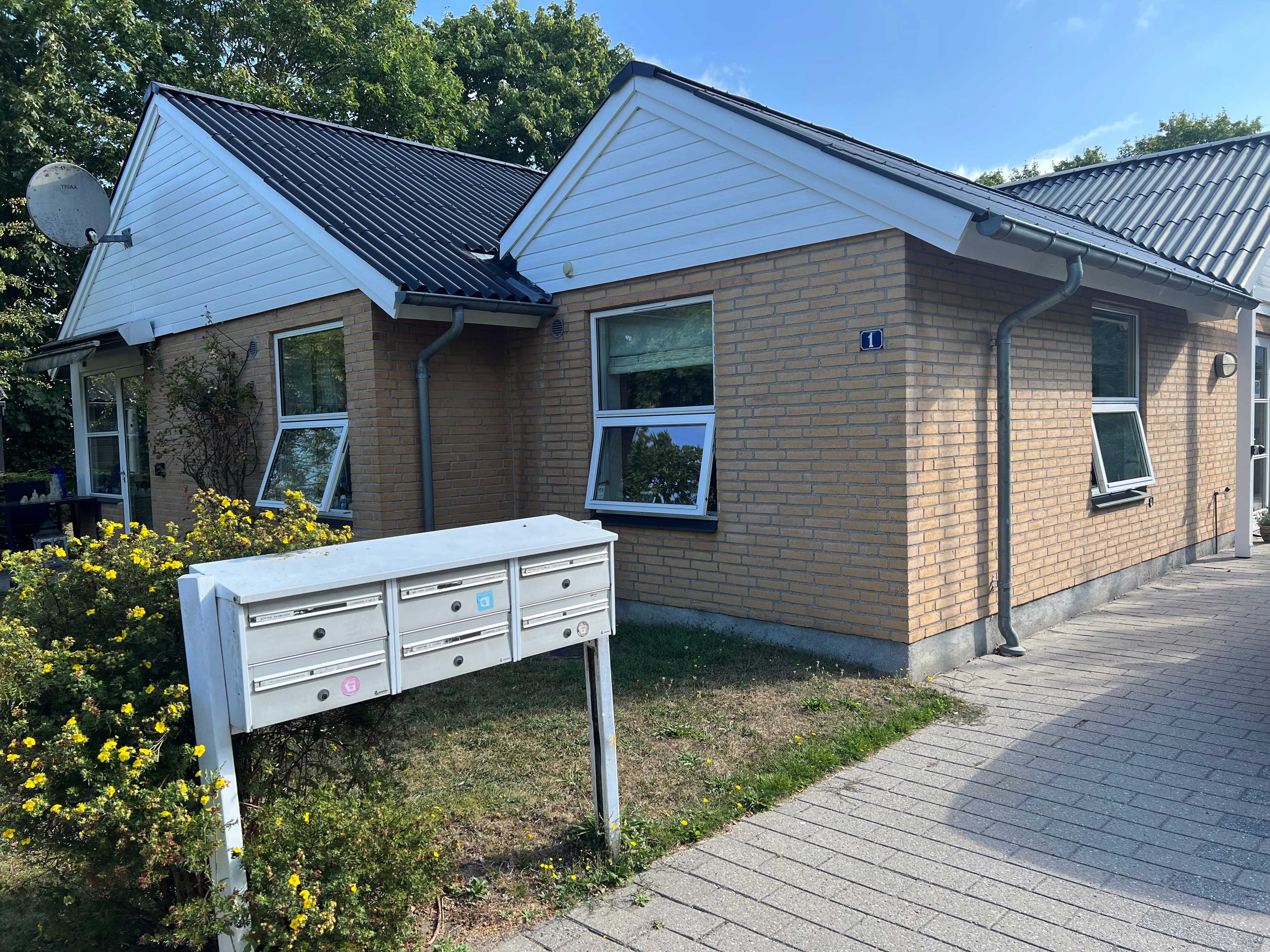 Lyngbakken set udefra. Der er et bord og seks stole.