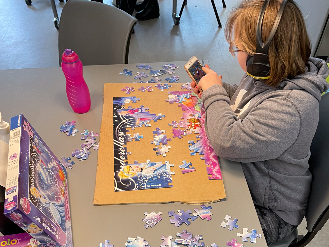 Person er ved at samle et puslespil. Det er Askepot, der er på puslespillet.