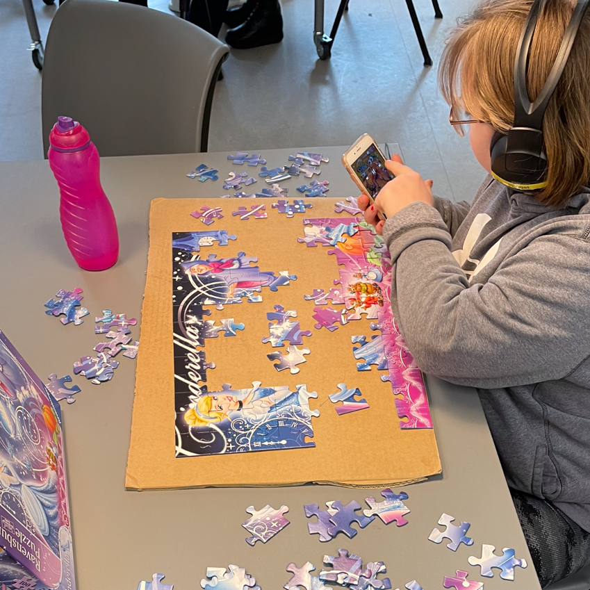 Person er ved at samle et puslespil. Det er Askepot, der er på puslespillet.