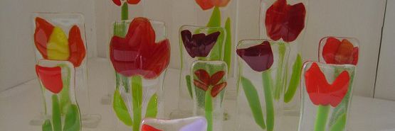 Fint kunst lavet af glas. Det forestiller blomster. De fleste er røde tulipaner.
