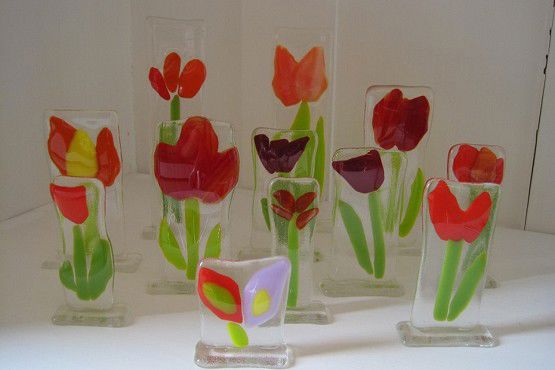 Fint kunst lavet af glas. Det forestiller blomster. De fleste er røde tulipaner.
